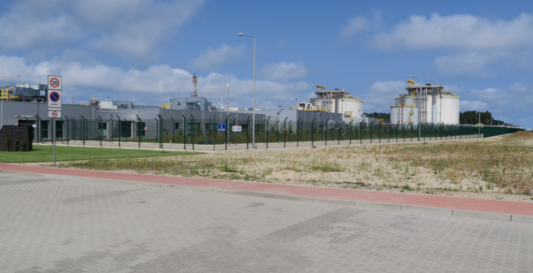 Valkoisia varastosäiliöitä ja teollisuusrakennuksia Świnoujścien LNG-terminaalissa Puolassa.